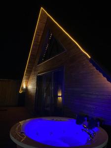 a large blue tub with lights on the side of a house at Maşukiye pink house bungalow in Kartepe