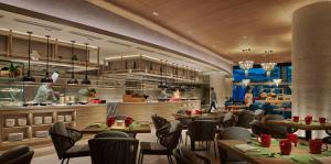 a restaurant with tables and chairs and a kitchen at PARKROYAL Langkawi Resort in Pantai Cenang +37 photos