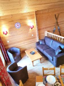 een woonkamer met een blauwe bank en stoelen bij Chalet de 4 chambres a Valmeinier a 500 m des pistes avec piscine partagee sauna et balcon in Valmeinier