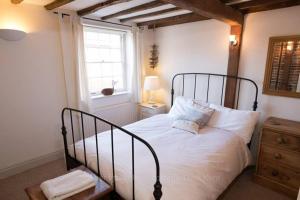 a bedroom with a bed with white sheets and a window at Copper Fish in Deal