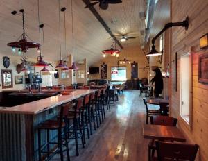un bar con una fila di sgabelli da bar in un ristorante di The Riverside - An Amish Built Log Cabin a Genoa