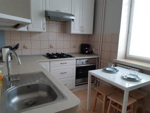 a kitchen with white cabinets and a sink and a stove at Żwirki centrum in Skierniewice