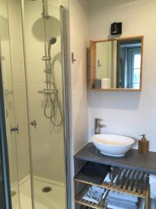 a bathroom with a glass shower and a sink at BenB La Fosse Bleue in Signy-lʼAbbaye