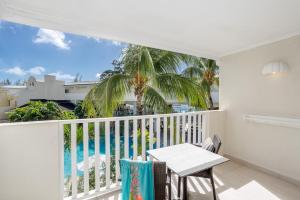 a balcony with a table and a view of the pool at Sugar Bay Barbados - All Inclusive in Bridgetown
