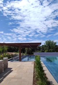 a pool with a pergola and a swimming pool at Resort em pirinopolis in Pirenópolis +1 photo