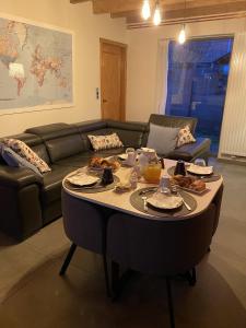 ein Wohnzimmer mit Sofa und Tisch mit Essen drauf in der Unterkunft CasaDeKaMa in Evergem
