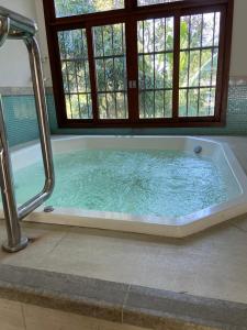 a large bath tub in a bathroom with a window at Apartamento em Pedra Azul, Condomínio Vista Azul in Pedra Azul +13 photos