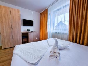 莫多比薩的住宿－Vila Victoria Moldovița，一间卧室配有一张带白色床单的床和一扇窗户。