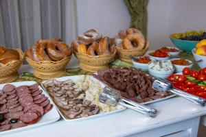 einen Tisch mit verschiedenen Fleischsorten und Brezeln in der Unterkunft Vila Victoria Moldovița in Moldoviţa