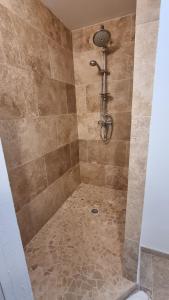 ducha con suelo de baldosa y cabezal de ducha en Mas provençal à proximité du Pont Du Gard, en Sernhac