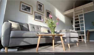 a living room with a couch and a table with flowers at Sommerhäuschen in Rheinsberg
