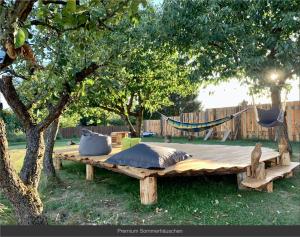 a wooden table with pillows and a hammock in a yard at Sommerhäuschen in Rheinsberg