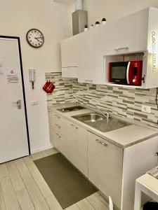 uma cozinha com um lavatório, um micro-ondas e um frigorífico em Leopolda Station em Florença