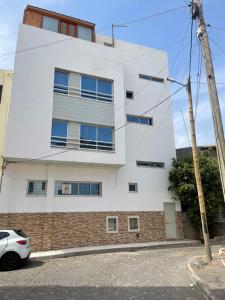 ein weißes Gebäude mit einem davor geparkt in der Unterkunft Quick Stay in Praia #2 in Praia
