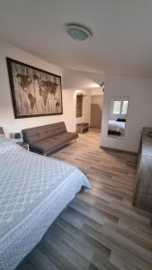 1 dormitorio con 1 cama y 1 sofá en Mas provençal à proximité du Pont Du Gard, en Sernhac