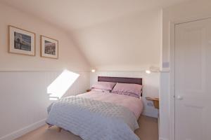 a bedroom with a bed in a white room at Liberty Cottage in Broadstairs