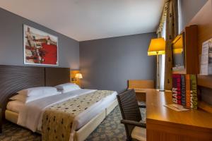 ブダペストにあるホテル ミュージアム ブダペストのベッドとデスクが備わるホテルルームです。