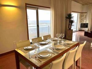 uma sala de jantar com uma mesa e cadeiras com vista para o oceano em Luxury Beachfront Apartment Las Canteras em Las Palmas de Gran Canaria