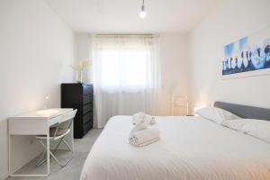 a white bedroom with a white bed and a desk at PrimoPiano - Caduti Missione in Milan
