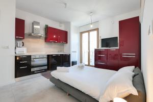 a kitchen with red cabinets and a large bed at PrimoPiano - Caduti Missione in Milan