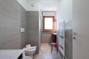 a bathroom with a toilet and a pink stool at PrimoPiano - Caduti Missione in Milan +30 photos