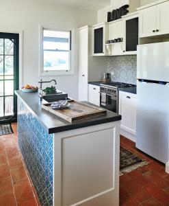 uma cozinha com armários brancos e uma bancada em Thamarra Cottage em Gleniffer