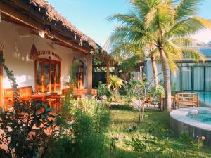 a house with a swimming pool and a palm tree at Khu Nghỉ Dưỡng Green Bungalow Phu Quoc in Phú Quốc