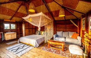 a bedroom with a bed and a couch in a room at Mansa Musso Treehouse Resort in Sanyang