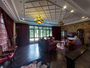 uma sala de estar cheia de mobiliário e um lustre em Templer Guesthome em Rawang