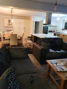 een woonkamer met banken en een tafel en een keuken bij 30 Heath Estate in Waldingfield