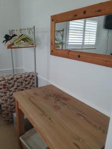 un tavolo in legno in una stanza con specchio di 30 Heath Estate a Waldingfield