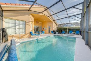 a large swimming pool with blue chairs in a building at Tuscan Pines Villa in Davenport