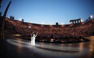 a woman standing in front of a crowd in an auditorium at Stadia Suite in Verona