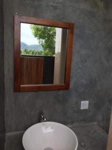 a bathroom with a sink and a mirror and a window at Takimi Mini Villa in Wellawaya