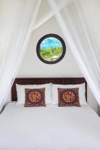 a bedroom with a bed with a round window at Takimi Mini Villa in Wellawaya