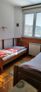 烏日策的住宿－Stan Uzice，带两张床和两个窗户的房间