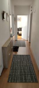 a hallway with three black rugs on the floor at Stan Uzice in Užice