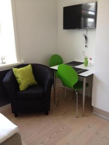 a living room with a couch and a table and green chairs at 12 Torvegade. 1 door 4. (id.154) in Esbjerg