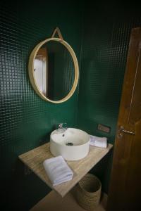 uma casa de banho verde com um lavatório e um espelho em Riad Sabria em Marrakech