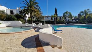 een zwembad met een blauwe stoel voor een gebouw bij Sao Rafel Beach house in Albufeira