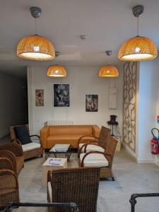 salon z kanapą, krzesłami i światłami w obiekcie L'Autre Lieu w mieście Cherbourg en Cotentin