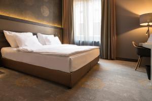 Habitación de hotel con cama con almohadas blancas en Hotel Museum Budapest, en Budapest
