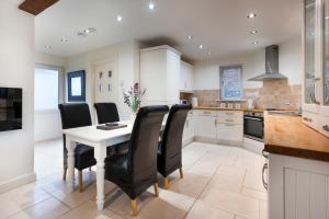 cocina con mesa blanca y sillas negras en The Pavilion, Clappersgate, en Ambleside