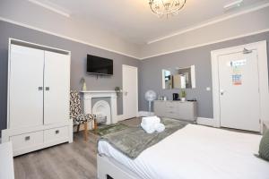a bedroom with a white bed and a fireplace at Hotel Anfield in Liverpool