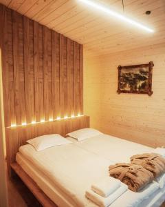a bedroom with a large bed in a wooden wall at IZKI Eco Resort in Izki