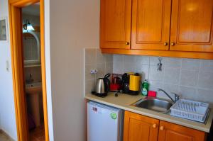 a kitchen with a sink and a counter top at Lagos Studios & Apartments in Palekastron