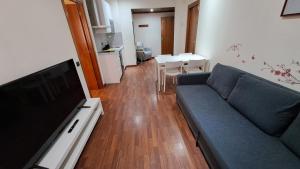 een woonkamer met een bank en een flatscreen-tv bij Hotel Suite Camarena in Teruel