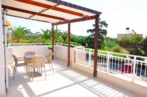 a patio with a table and chairs on a balcony at Lagos Studios & Apartments in Palekastron