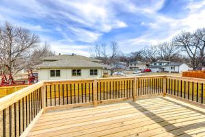 a wooden deck with a fence in front of a house at Pet-Friendly Omaha Vacation Rental with Deck! in Omaha