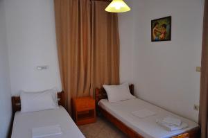 a room with two beds and a window at Lagos Studios & Apartments in Palekastron